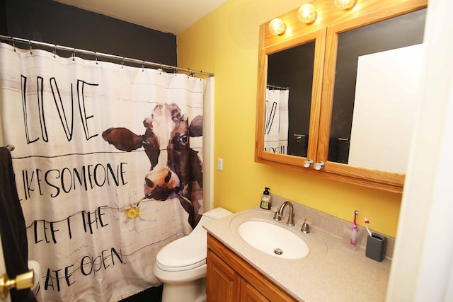 bathroom featuring toilet, a shower with shower curtain, and vanity