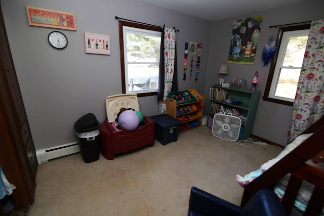 rec room featuring a baseboard heating unit, carpet floors, and a wealth of natural light