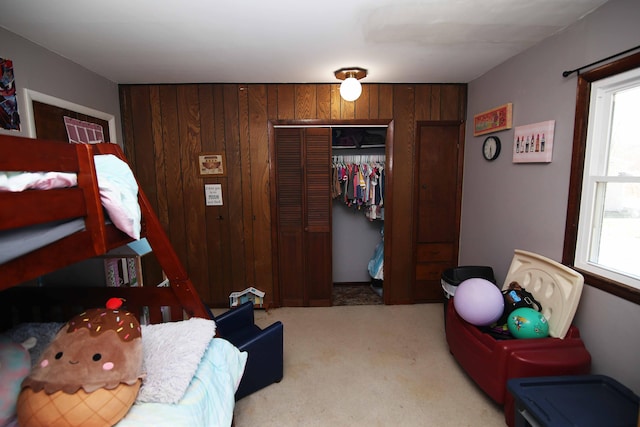 bedroom featuring wood walls, a closet, and carpet flooring