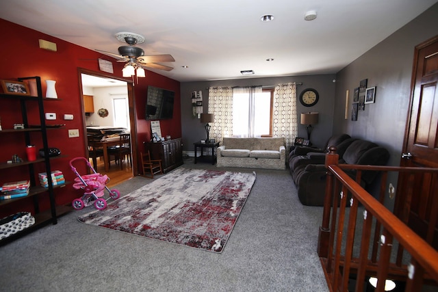 carpeted living area with ceiling fan