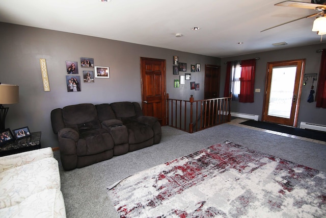 carpeted living area with a baseboard heating unit, ceiling fan, and visible vents