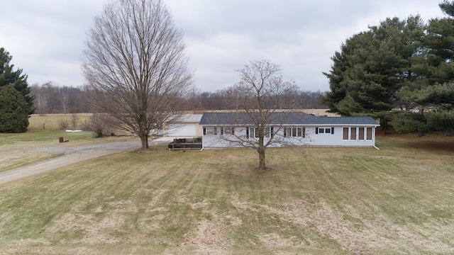 ranch-style home featuring driveway and a front lawn