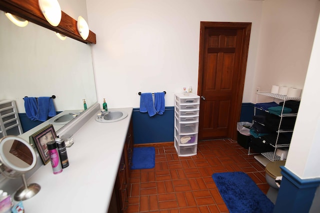 bathroom with vanity and brick patterned floor