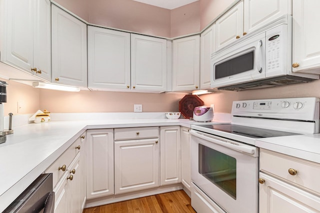 kitchen featuring light wood finished floors, light countertops, white appliances, and white cabinets