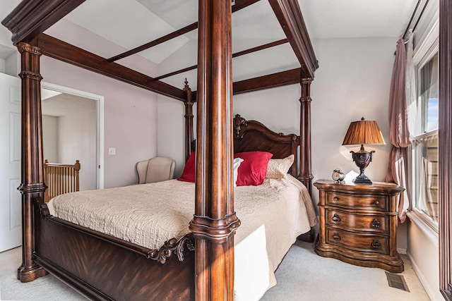 carpeted bedroom featuring lofted ceiling and visible vents