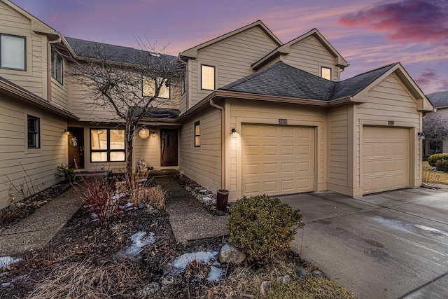 view of front of home featuring a garage, concrete driveway, and roof with shingles