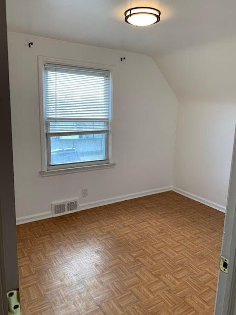 bonus room with vaulted ceiling, visible vents, and baseboards