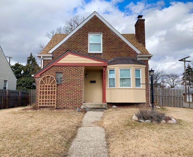 view of front of property with a chimney, fence, a front lawn, and brick siding