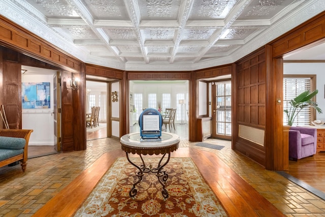 interior space with ornamental molding, wood-type flooring, and coffered ceiling