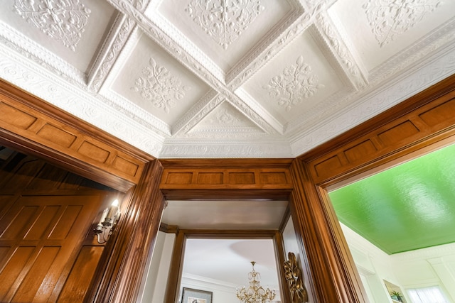 room details featuring crown molding, coffered ceiling, and a notable chandelier