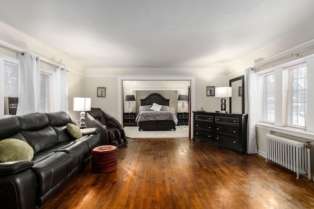 bedroom featuring radiator heating unit and hardwood / wood-style flooring