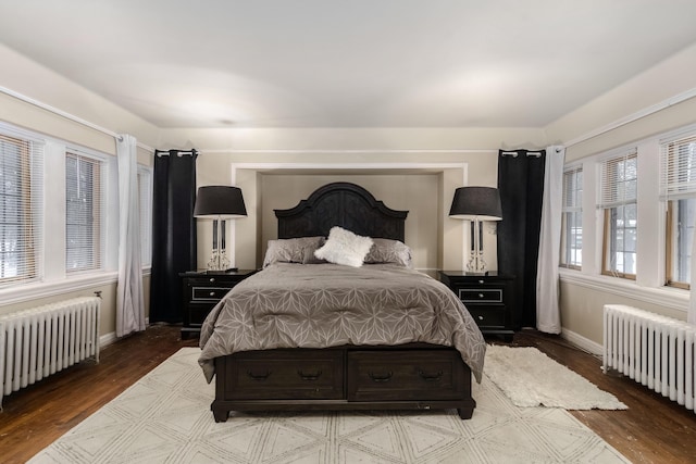 bedroom featuring radiator, baseboards, and wood finished floors