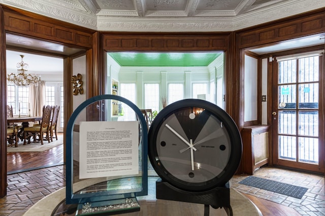 interior space with an ornate ceiling, a notable chandelier, and crown molding