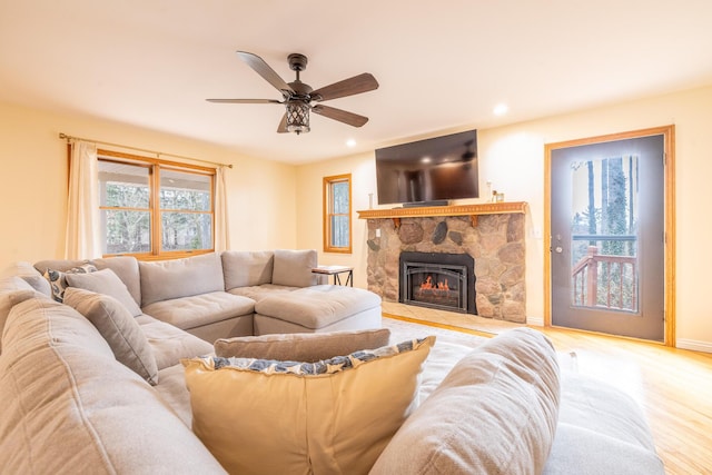 living area featuring baseboards, a ceiling fan, wood finished floors, a fireplace, and recessed lighting