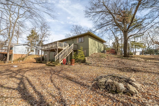 rear view of house with stairway and a wooden deck