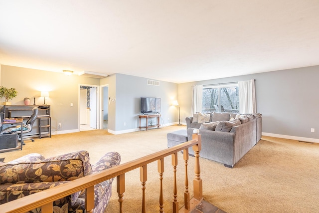 living area featuring baseboards, visible vents, and light colored carpet