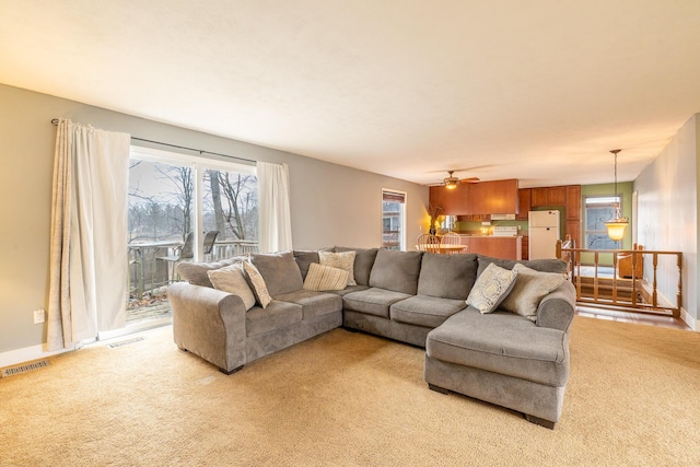 living room featuring baseboards, visible vents, and light colored carpet