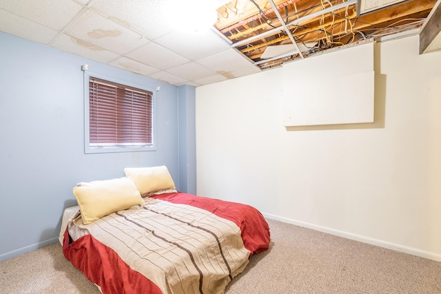 bedroom with carpet floors, baseboards, and a paneled ceiling