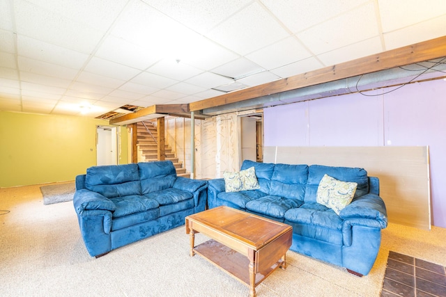 carpeted living area with a paneled ceiling and stairway