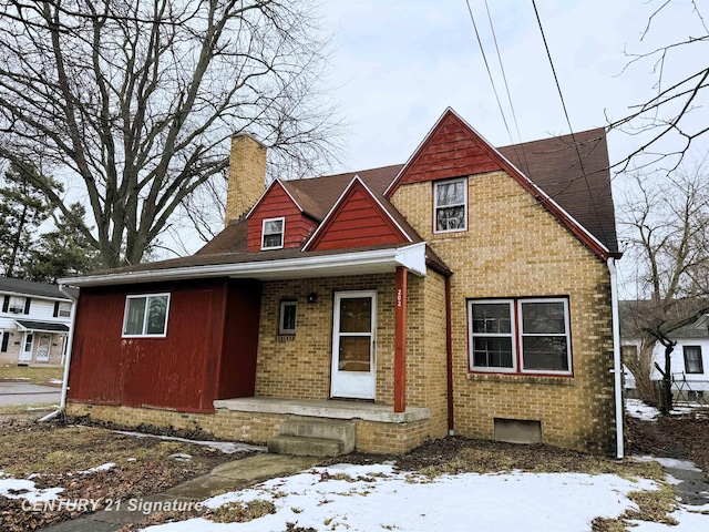 view of front of property featuring brick siding and a chimney