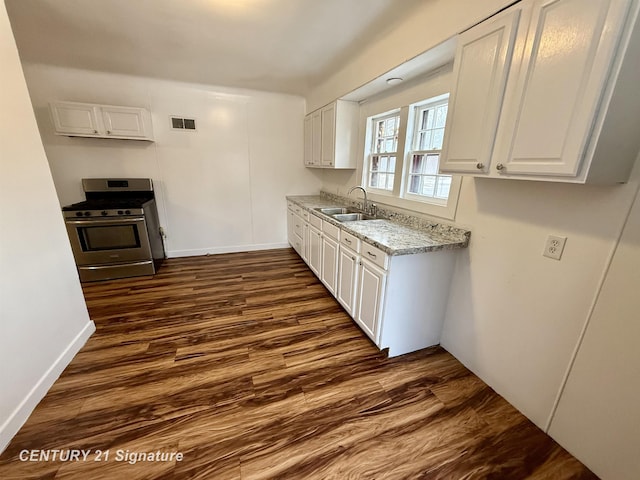 kitchen with a sink, visible vents, white cabinets, stainless steel range with gas cooktop, and dark wood finished floors