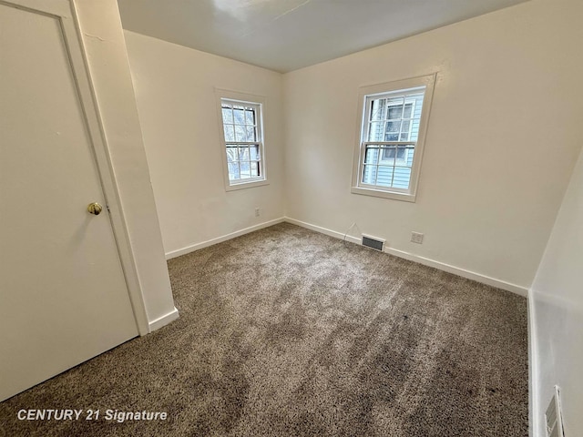 unfurnished bedroom with carpet, visible vents, and baseboards