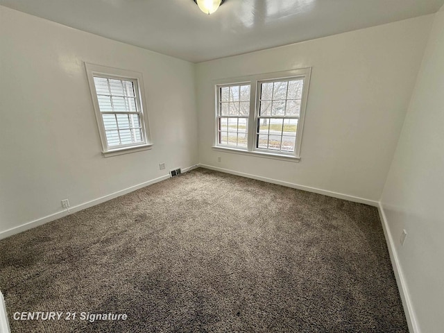 unfurnished room with visible vents, baseboards, and carpet flooring