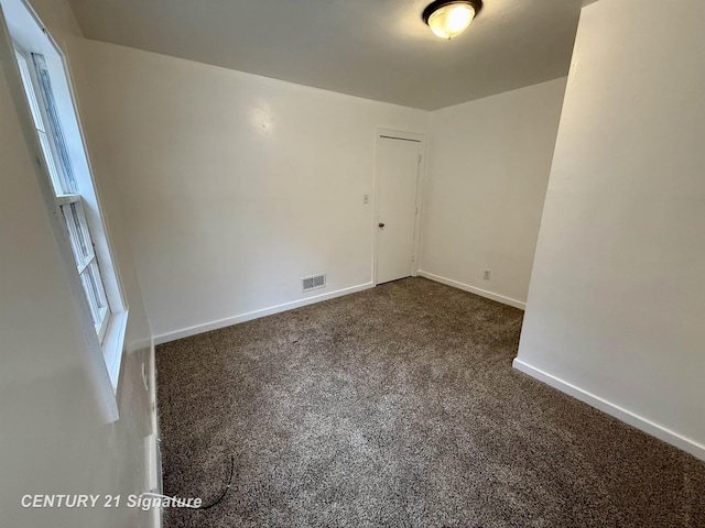 carpeted spare room with visible vents and baseboards