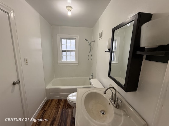 bathroom featuring bathing tub / shower combination, visible vents, toilet, a sink, and wood finished floors