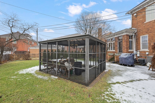 view of outbuilding featuring a sunroom and fence