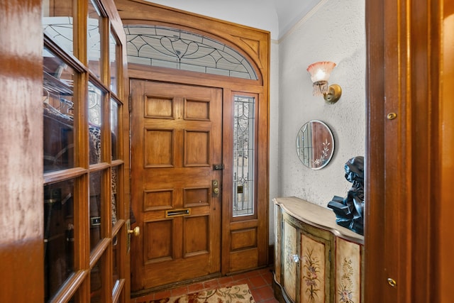 entrance foyer with dark tile patterned flooring and a textured wall