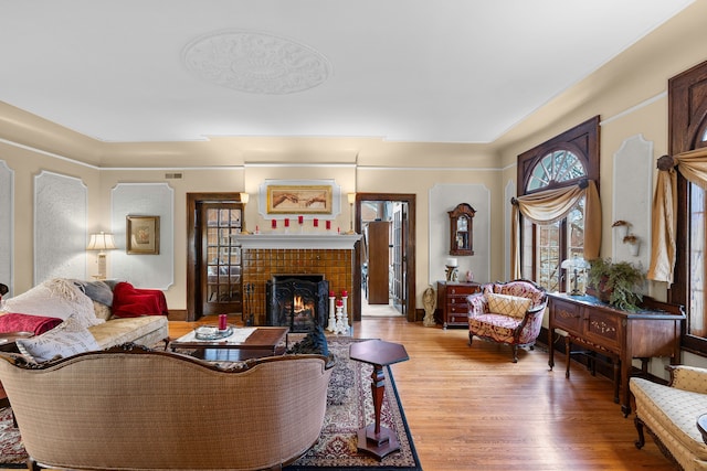 living room with light wood finished floors and a tiled fireplace