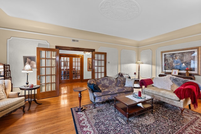 living area with light wood-style flooring, visible vents, and french doors