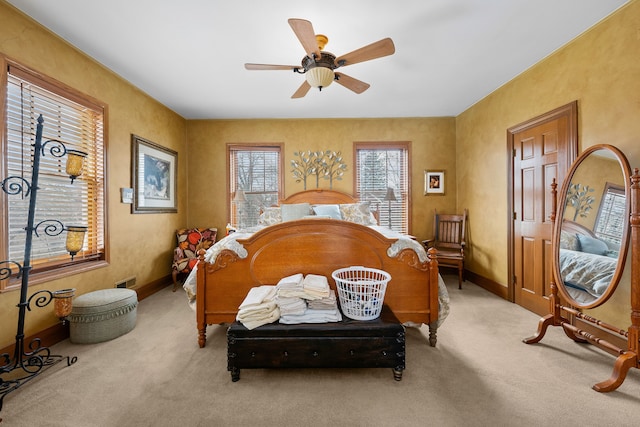 bedroom with light colored carpet, ceiling fan, visible vents, and baseboards