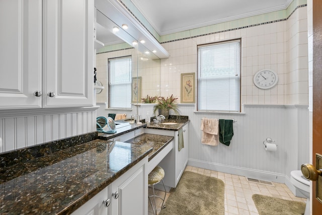 bathroom with crown molding, visible vents, toilet, vanity, and tile patterned floors