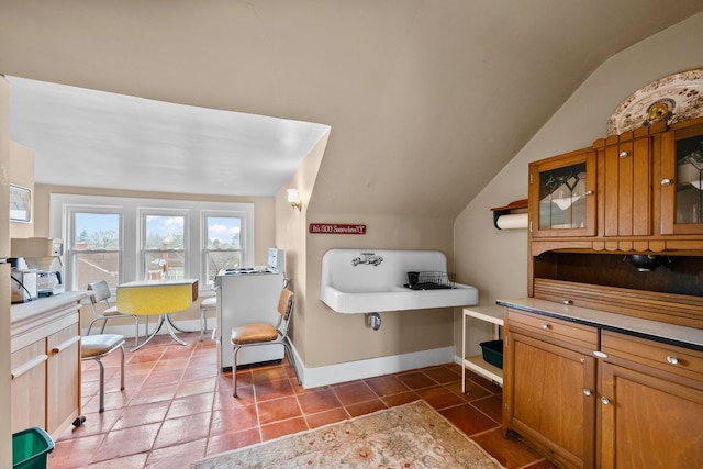 bathroom featuring lofted ceiling, baseboards, and tile patterned floors