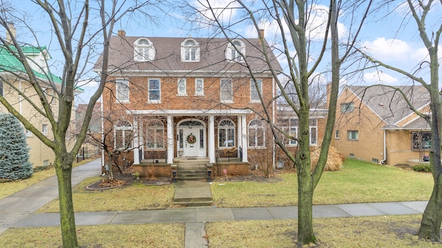 view of front facade featuring brick siding and a front lawn