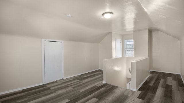 additional living space featuring lofted ceiling, baseboards, and wood finished floors