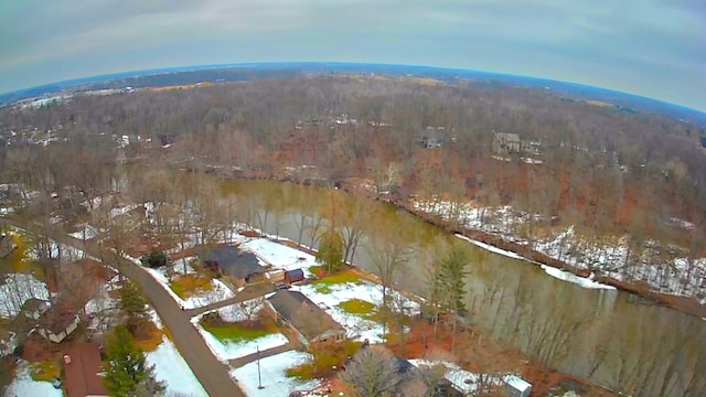 snowy aerial view featuring a wooded view