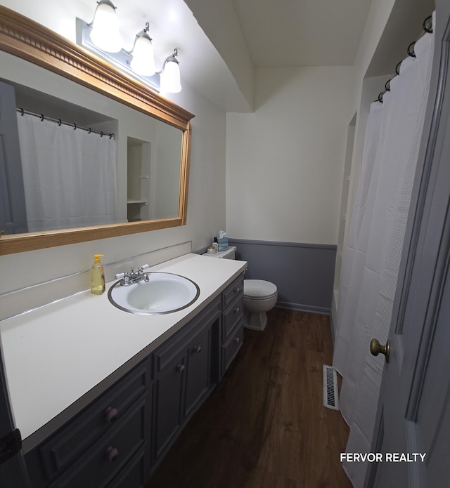 bathroom with curtained shower, visible vents, toilet, vanity, and wood finished floors