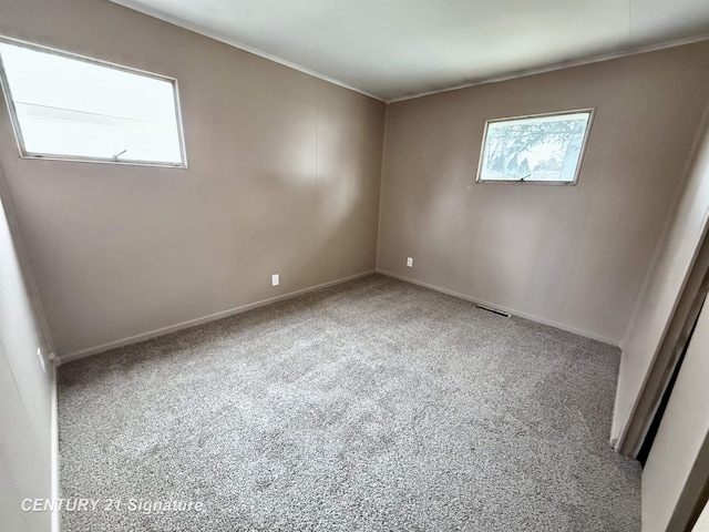 carpeted spare room featuring visible vents