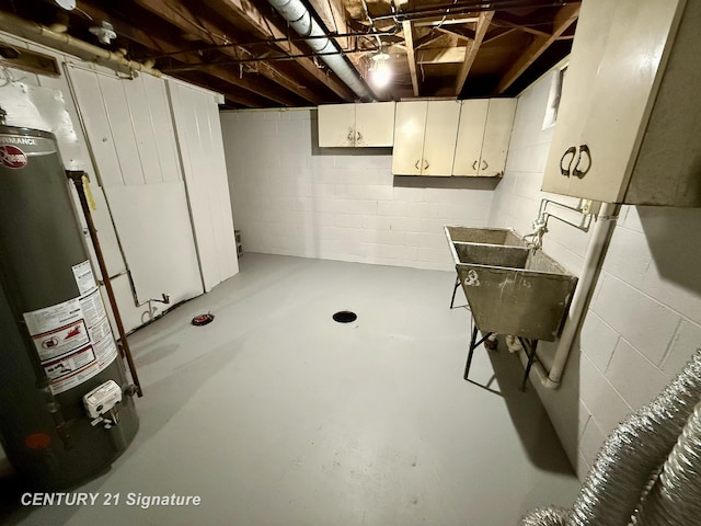 unfinished basement featuring concrete block wall, a sink, and gas water heater