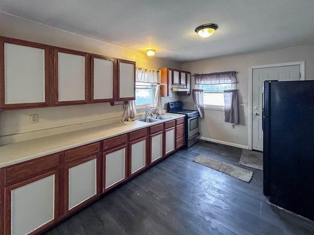 kitchen with electric stove, dark wood-style flooring, freestanding refrigerator, light countertops, and a sink