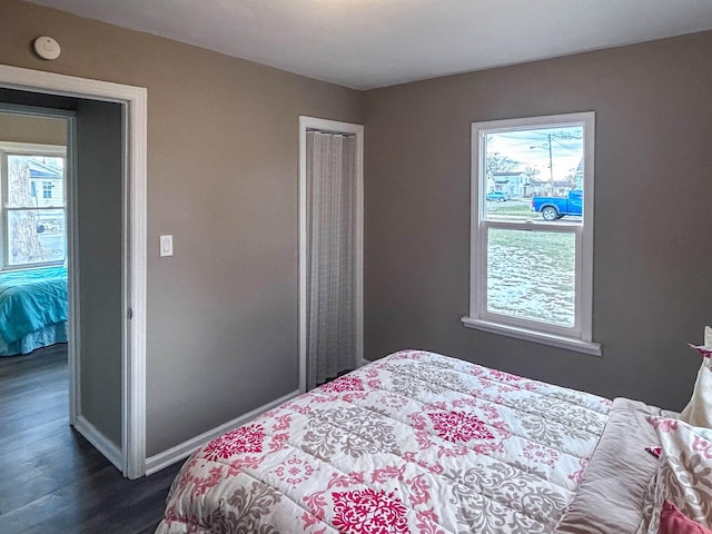 bedroom featuring a closet, dark wood finished floors, and baseboards