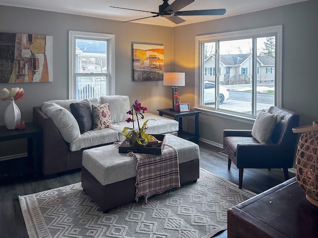 living area featuring baseboards, plenty of natural light, a ceiling fan, and wood finished floors