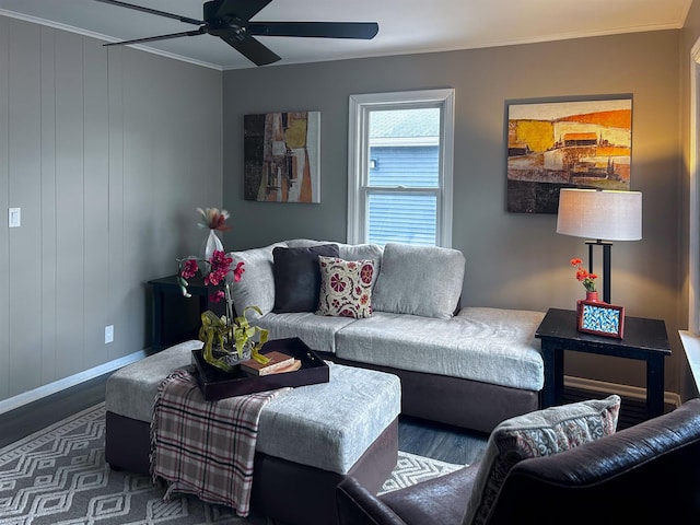 living room with a ceiling fan, baseboards, ornamental molding, and wood finished floors