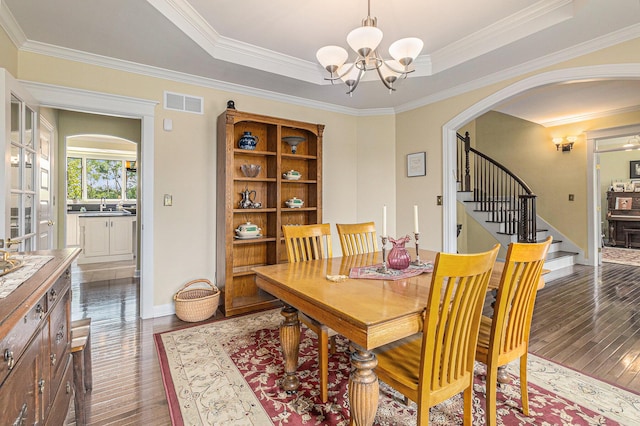 dining space featuring arched walkways, stairway, a raised ceiling, and visible vents