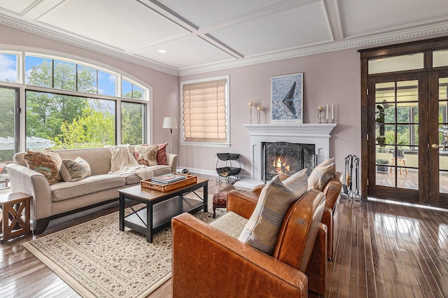 living room with a warm lit fireplace, coffered ceiling, hardwood / wood-style floors, and a healthy amount of sunlight