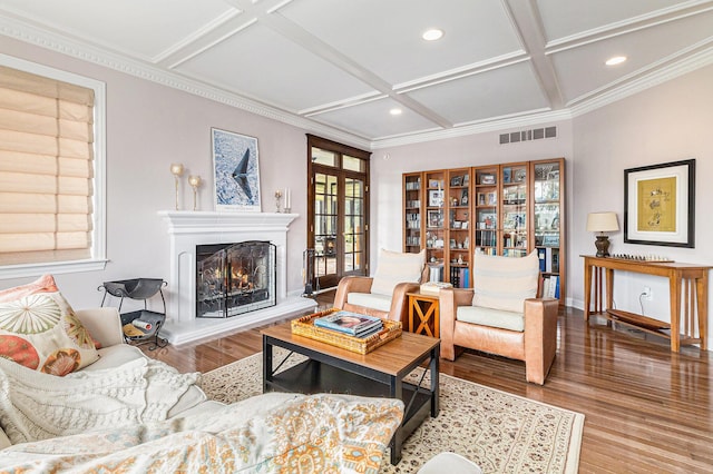 living area with a warm lit fireplace, visible vents, coffered ceiling, wood finished floors, and recessed lighting