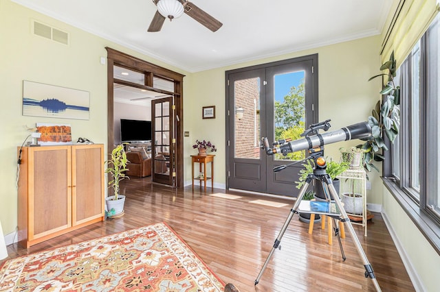 interior space with hardwood / wood-style flooring, visible vents, baseboards, french doors, and crown molding